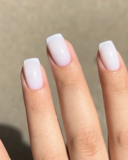 French manucure sur ongles carrés courts, gros plan sur la main