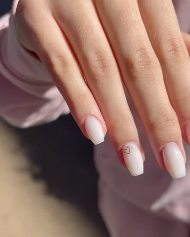 Ongles baby boomer en dégradé blanc, avec un petit cœur dessiné