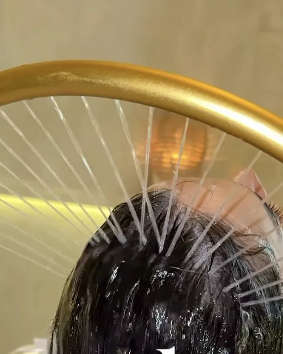 Headspa au bac, anneau doré et fine pluie d'eau sur les cheveux