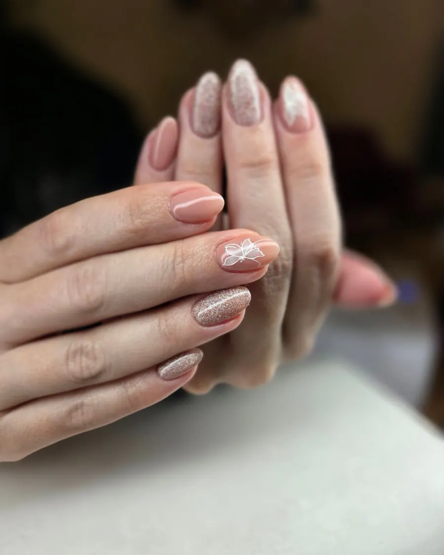 Mains posées l'une sur l'autre, ongles amande en vernis nude